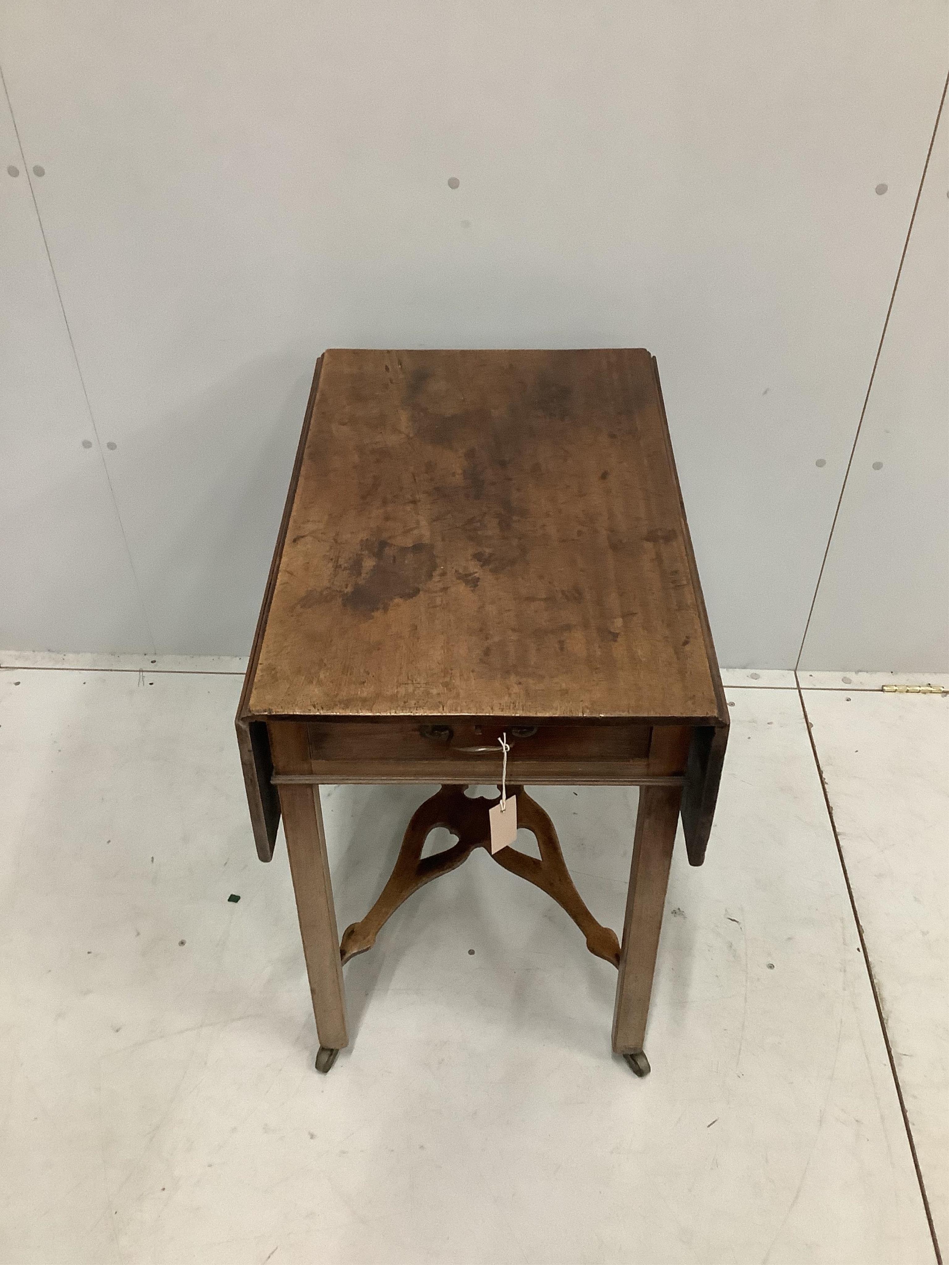 A George III mahogany Pembroke table, with shaped pierced cross stretcher, on chamfered legs with castors, width 47cm, depth 71cm, height 71cm. Condition - fair